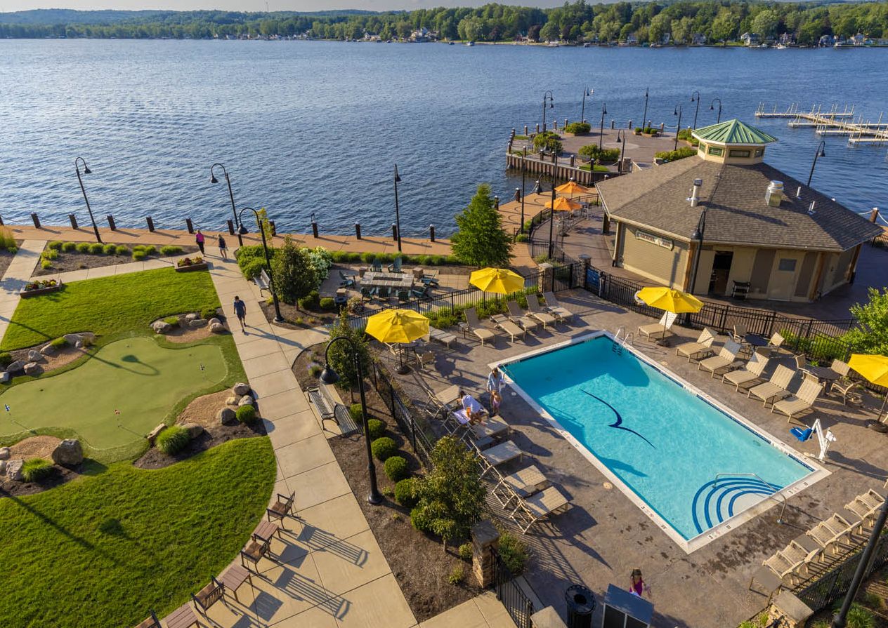 The exterior of the Chautauqua Harbor Hotel in summer with Chautauqua Lake in the background.