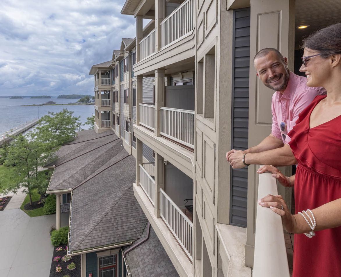 A couple taking in the view from their balcony at the 1000 Islands Harbor Hotel