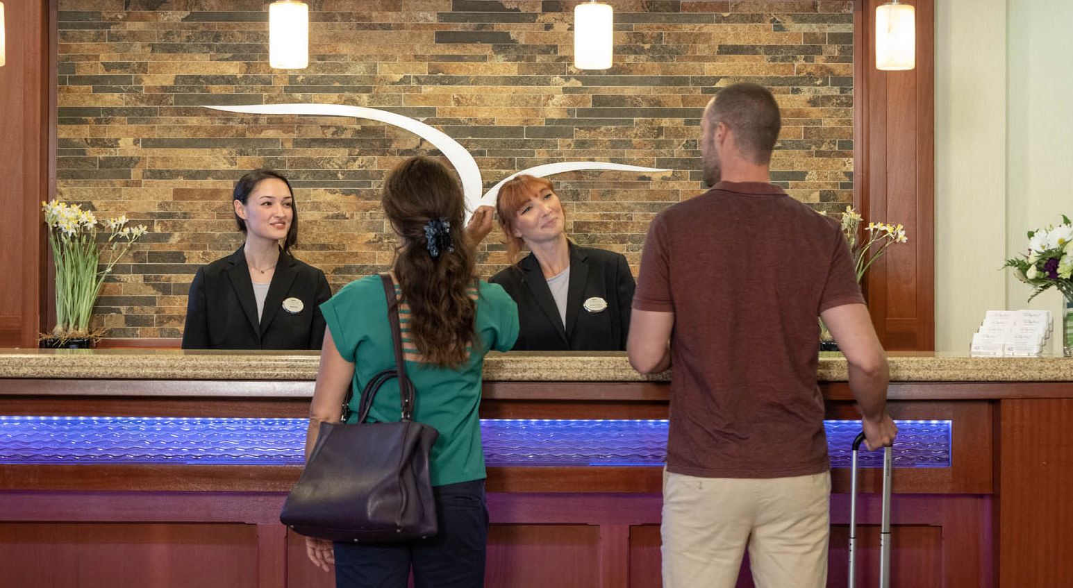 A couple greets the attendants at the front desk of the 1000 Islands Harbor Hotel