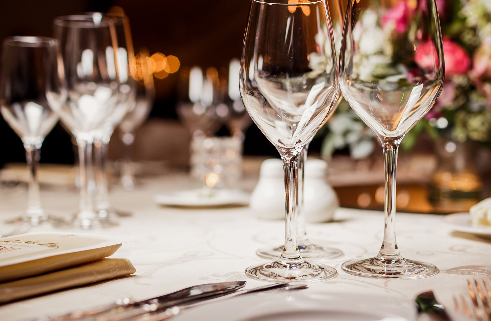 A close-up on a table with white tablecloth and silverware set for a corporate meeting