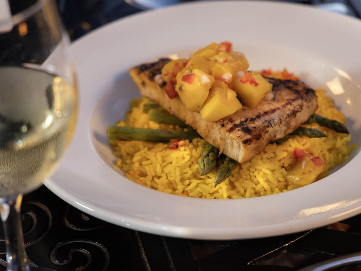 A delicious plate featuring swordfish steak with asparagus served over rice