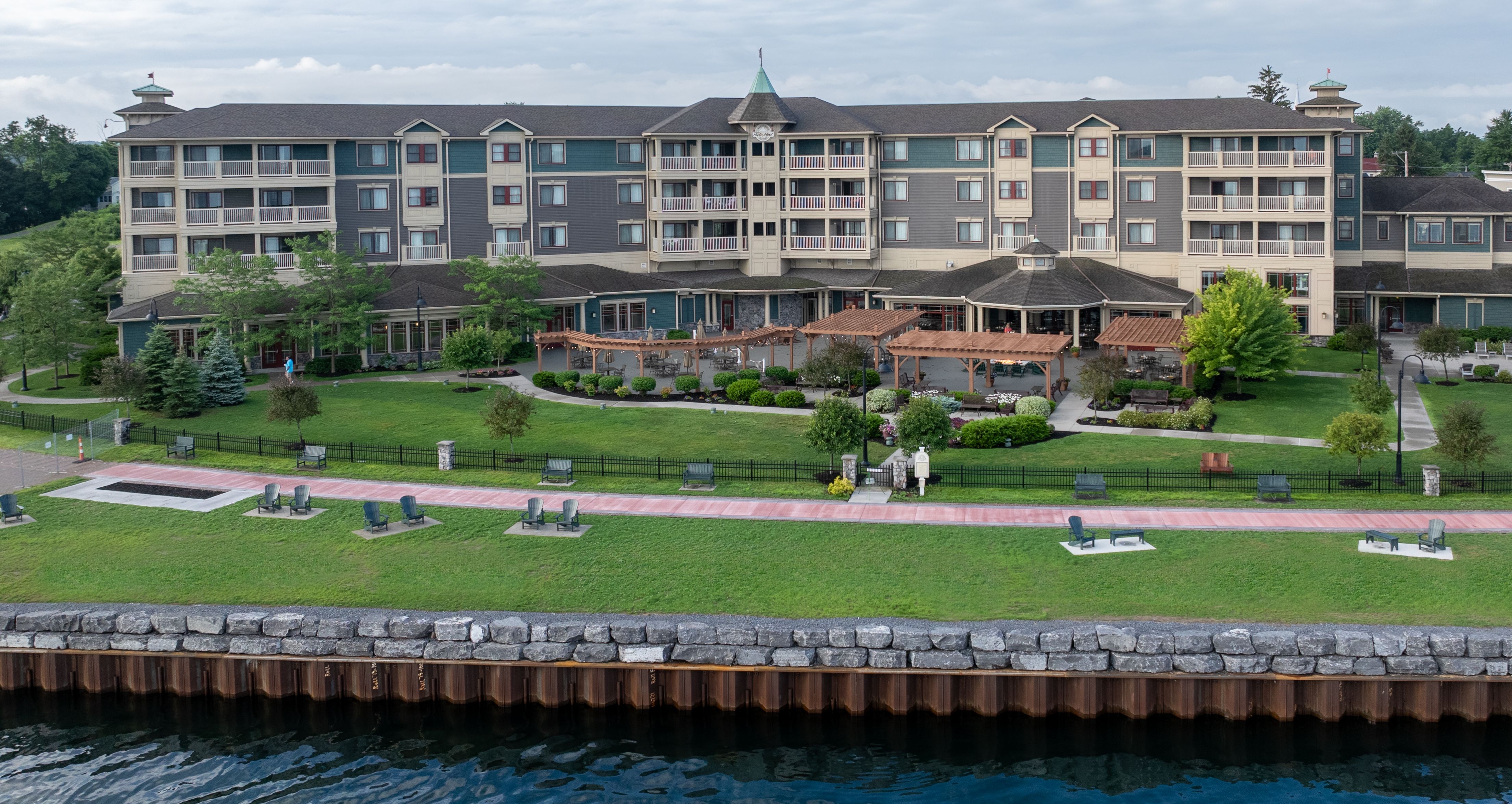 An aerial view of the 1000 Islands Harbor Hotel from the water, showcasing the front lawn and grounds